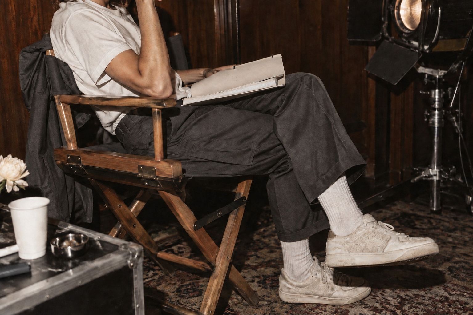 A performer with a ivory script binder in a walnut director chair